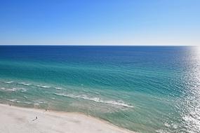 Beautiful sandy beach, near the turquoise and blue water of the Gulf of Mexico, at blue sky on background