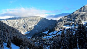 mountain peaks in the snow under the sky with clouds