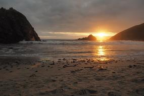 setting sun behind dark clouds on the coast