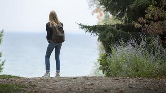 photo of a girl with a backpack on the seashore