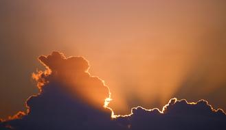 bright sun behind dark clouds in the sky
