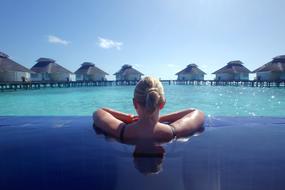 girl in the pool overlooking the ocean in the maldives