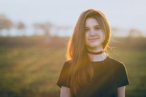 Beautiful, smiling girl, on the beautiful and colorful field, at beautiful and colorful sunset