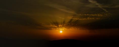 Beautiful and colorful sunset in the sky, with the clouds, above the landscape