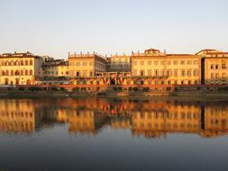 historical architecture is reflected in the river Arno