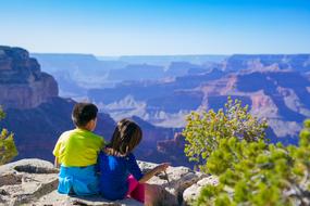children sit on top of a mountain in Grand Canyon, Arizona
