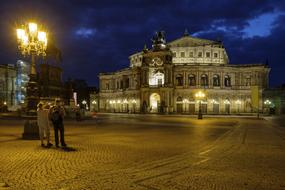 tourists in the square near the opera house at night