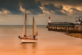 sailboat on orange water at dusk
