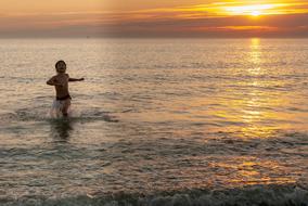 child on sea Beach at sunset