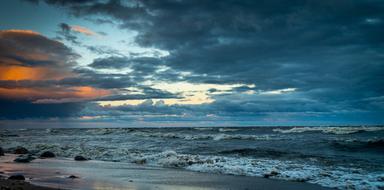 Waves splashing on beach at dusk