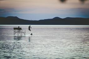 Person, jumping in the beautiful Lake Balaton, among the mountains in Hungary