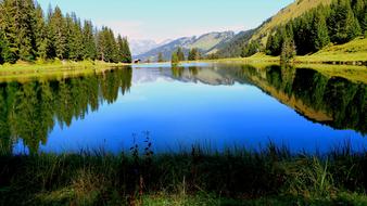 Beautiful landscape with the lake, among the green mountains and trees