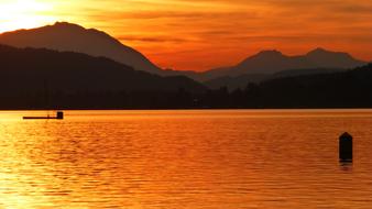 Beautiful waterscape under colorful sunset with mountains on the shore