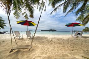 sun loungers under umbrellas on the beach on the island