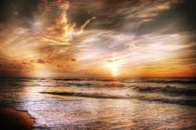 Beautiful landscape with the sandy beach, at colorful sunset on horizon, in Denmark