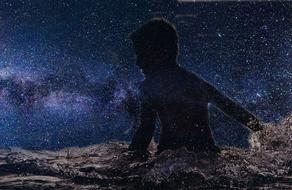 silhouette of a child swimming in the galaxy