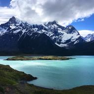 white clouds over mountain lake with turquoise water