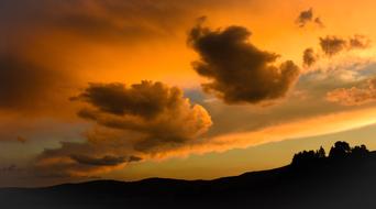 clouds in orange light over the hill in the evening