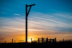 Silhouette of the Winter's Gibbet, in Elsdon, Northumberland, England, at beautiful and colorful sunset