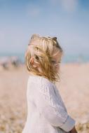 little girl on the street during the wind on a blurred background