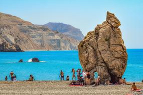 people and big rock on Sea Coast