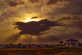 sun rays in dark clouds over a city in cyprus