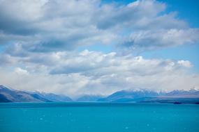 Beautiful landscape with the turquoise water, among the mountains, under the clouds in the sky, in New Zelanad