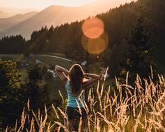 Girl, among the beautiful mountains, at colorful sunset, in autumn