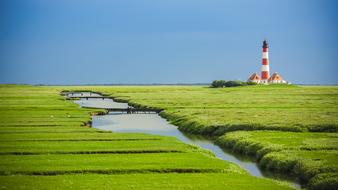 striped lighthouse in the Leuchturm Westerheversand nature reserve in Germany