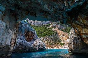 Beautiful grotto with the turquoise water, in the mountains with green plants, in Corsica, France