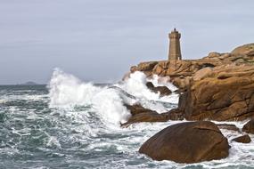 Foam waves on the rocks near the lighthouse
