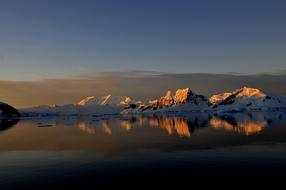 ice on the mountains in antarctica at sunset