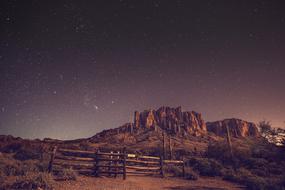 Beautiful landscape of the rocks, among the plants, and fence, at colorful and beautiful sky with the stars