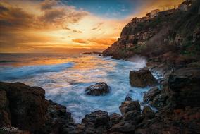 Beautiful landscape of the rocky coast, with the waves, at beautiful and colorful sunset