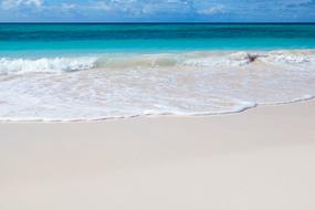 foamy clear wave splashing on sand beach