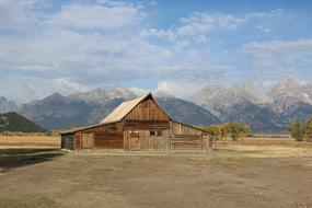 Beautiful landscape with the barn, among the colorful trees and mountains, in Wyoming, USA