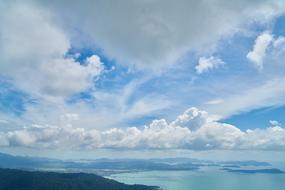 white clouds in the sky over the sea