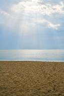 Beautiful landscape of the sandy beach, in sunlight, under the blue sky with clouds