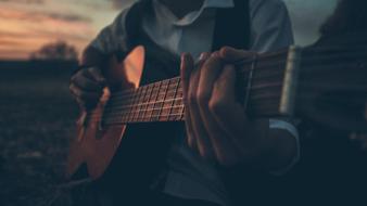 guitarist at dusk close up on blurred background