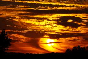 orange sunset in the clouds over black silhouettes