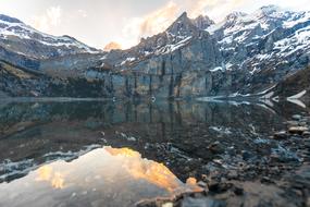 Beautiful landscape with the Oeschinen lake, among the snowy, rocky hills in Switzerland