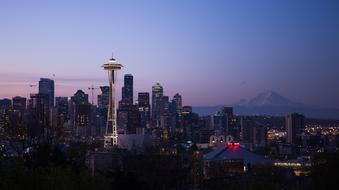 Beautiful cityscape of Seattle, USA, with the colorful lights, at beautiful and colorful sunset, at background with the mountains