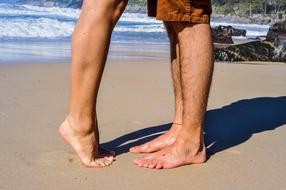 photo of couple feet on the beach