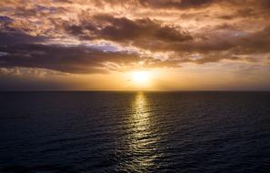 sunset in dark clouds over the ocean