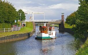 Colorful paddle steamer on the water, among the colorful plants, in Carolinensiel, East Frisia, Germany