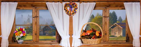 a vase of flowers and a basket of vegetables on a wooden windowsill