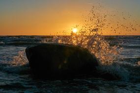 Sea with waves, at colorful and beautiful sunset on horizon