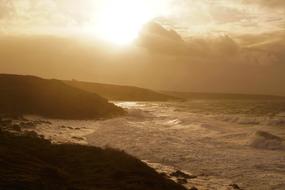 sun in the clouds over the sea waves