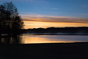 Landscape of the beautiful lake among the trees, at colorful and beautiful twilight