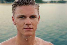 wet guy near the water on a blurred background